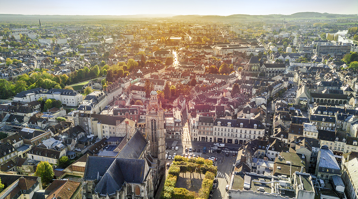 aerial view of pretty French town with green trees and old church
